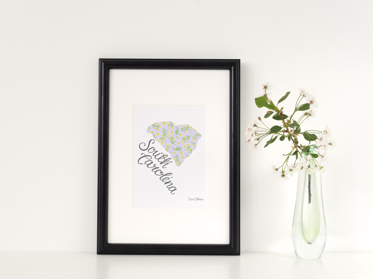 Framed artwork of South Carolina with a vase of flowers on a white background